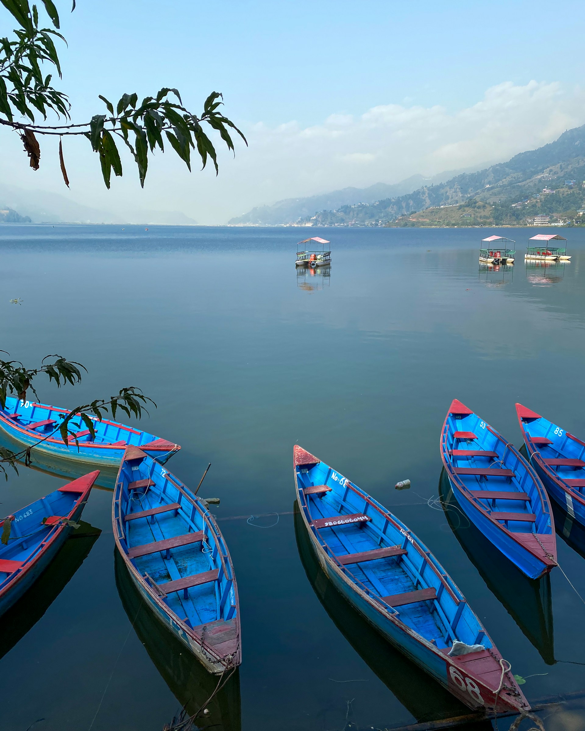 Photo of fewa lake with empty boats on front